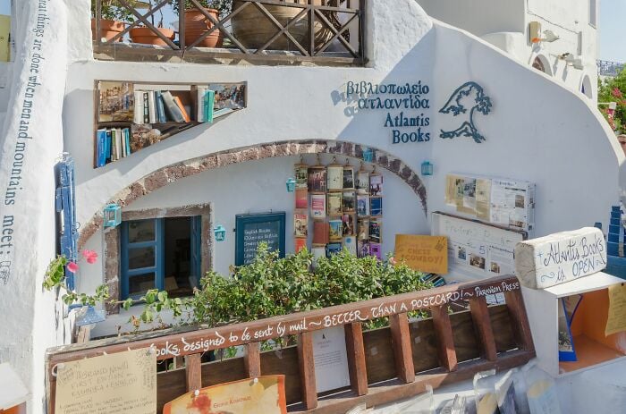 Exterior de biblioteca aconchegante e grandioso com livros e plantas, exibindo um ambiente mágico de livraria de todo o mundo.