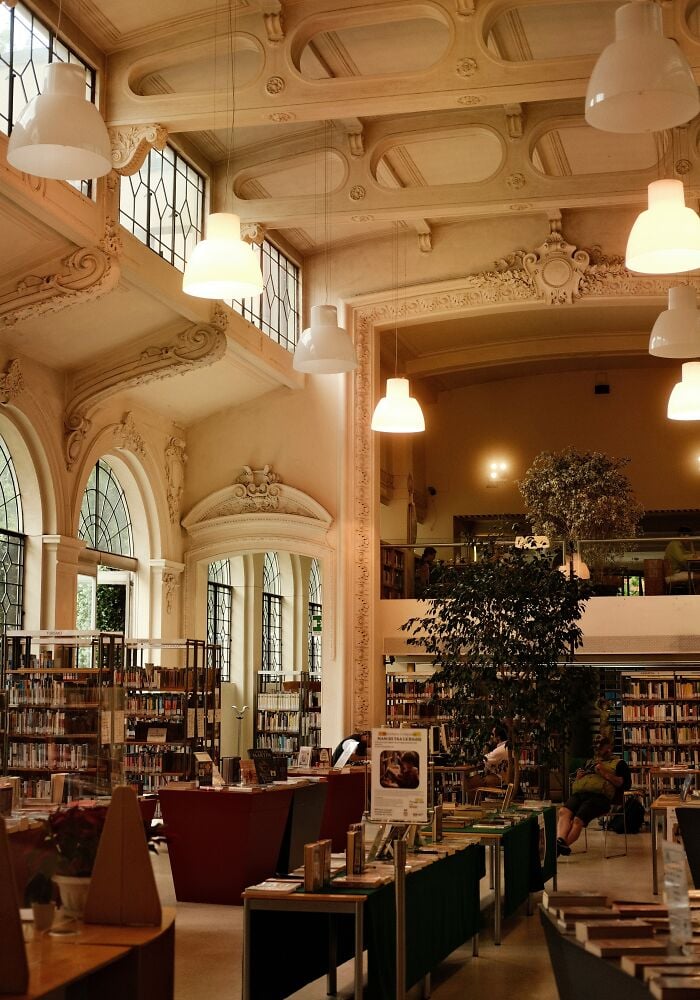 宏偉的圖書館內部，擁有高聳的天花板、華麗的建築、大窗戶、書架和舒適的閱讀區。