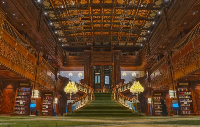 宏偉的圖書館內部，設有宏偉的樓梯、木製華麗的牆壁和擺滿書籍的書架，置身於奇幻的氛圍中。