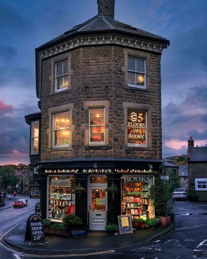 Cozy and grandiose bookstore with warm lights in a historic stone building showcasing magical library charm.